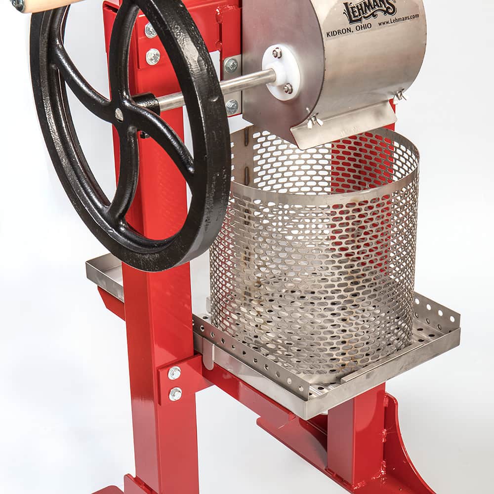 Handcrafted Lehman’s fruit press featuring a red frame, stainless steel mesh basket, and black cast iron crank wheel, ideal for orchard use and featured in Farm, Garden & Tool collections.