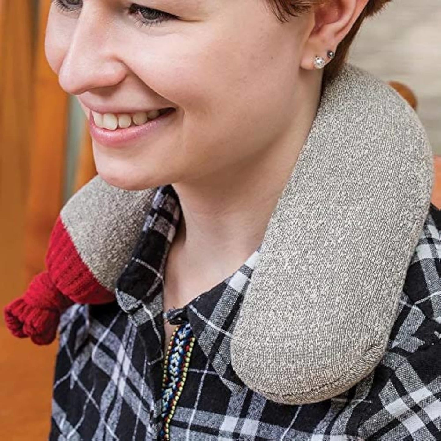 Smiling person wearing a handcrafted black walnut hot pack around the neck, designed for soothing aches and pains, made in USA and featured in Health & Wellness collections.