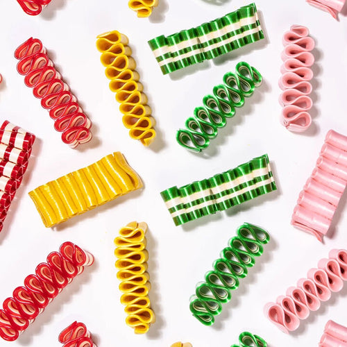 Assorted handspun ribbon candy in vibrant red, yellow, green, and pink hues with distinct stripes, handcrafted in the USA, ideal for Kitchen & Food, Snacks and Sweets collections.
