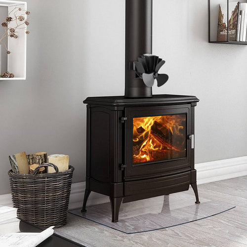 Black heat-powered magnetic stove fan with three curved blades mounted on a vertical pipe above a wood-burning stove, designed to enhance warm air circulation in Stoves, Hearth Accessories, Best Sellers, Promo Eligible, and All Stoves & Appliances collections.