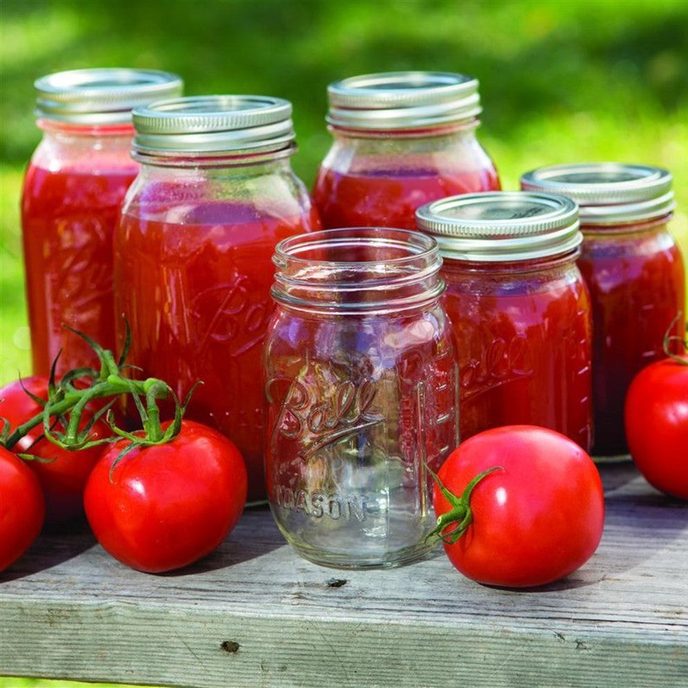 Set of clear glass canning jars with metal lids, some filled with homemade tomato sauce and fresh tomatoes nearby, showcasing classic jars ideal for Kitchen & Food, Food Preservation, and USA Made collections.