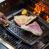 Handcrafted cast iron grill topper pan with perforated surface for enhanced smoky flavor, shown grilling tuna steaks and lemon halves, ideal for Kitchen & Food and Cast Iron collections.