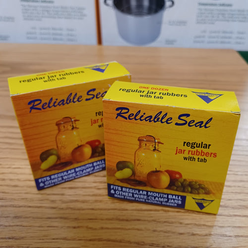 Two yellow vintage-style boxes labeled Reliable Seal containing regular jar rubbers with tabs for canning jars, displayed on a wooden surface for Kitchen & Food and Food Preservation collections.