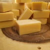 Handcrafted yellow turmeric soap bars stacked on a natural wood surface, highlighting their organic, handmade quality, featured in Health & Wellness, Soaps, and Best Sellers collections.