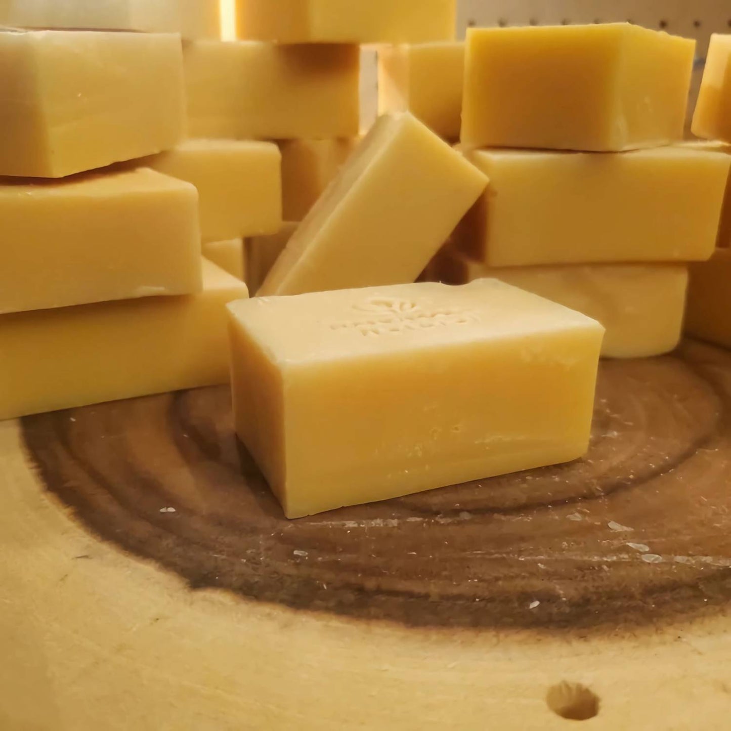 Handcrafted yellow turmeric soap bars stacked on a natural wood surface, highlighting their organic, handmade quality, featured in Health & Wellness, Soaps, and Best Sellers collections.