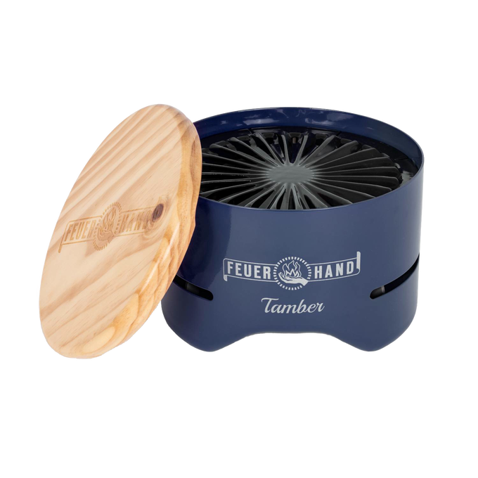 Compact tabletop charcoal grill with a durable navy blue metal body and a removable wooden lid featuring a branded burned-in logo, ideal for camping and outdoor grilling.