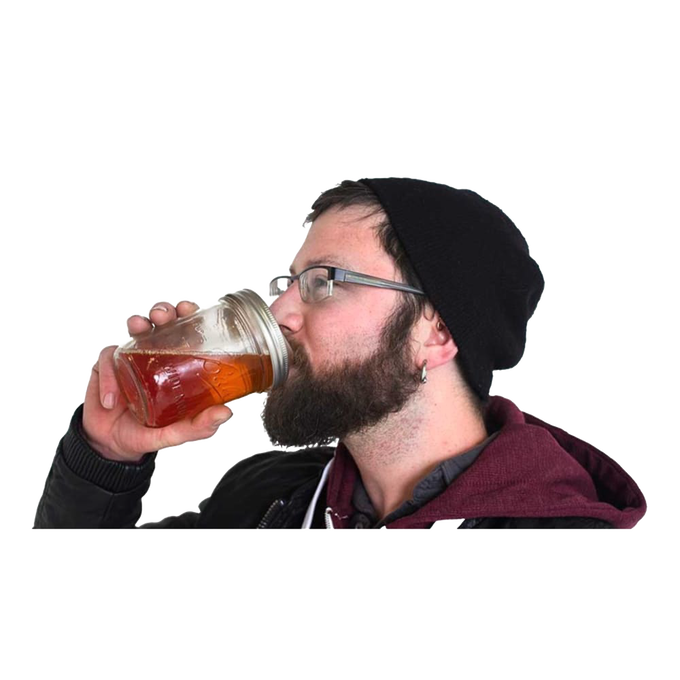 Man wearing glasses and a black beanie sipping a drink from a wide-mouth mason jar with a clear reusable drinking lid, part of Kitchen & Food, USA Made, and Best Sellers collections.