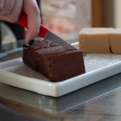 Handcrafted rich chocolate and creamy beige fudge pieces being sliced on a white tray, perfect for Kitchen & Food, Snacks and Sweets, Best Sellers, and Promo Eligible collections.