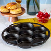 Round cast iron mini cake pan with seven cavities and handles, handcrafted for even baking, ideal for Kitchen & Food, Cast Iron, Baking Supplies, USA Made, and Best Sellers collections.