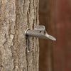 Metal spile securely inserted into mature tree bark, used for collecting sap, suitable for farm, garden, orchard, and maple syrup sugaring supplies, crafted for durable use.