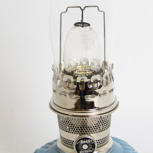 Close-up view of a handcrafted burner with perforated metal design and clear textured glass chimney on a limited edition blue glass base oil lamp, featured in Lamps & Lighting, Oil Lamps, Table Lamps, Best Sellers, and Promo Eligible collections.
