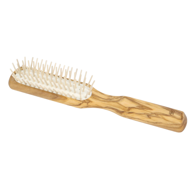 Handcrafted olive wood hairbrush with five rows of straight hornbeam pins, designed for gentle detangling and scalp comfort, featured in Health & Wellness and Grooming collections.