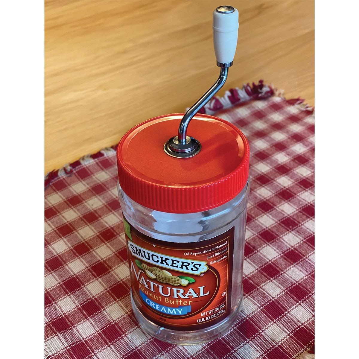 Handcrafted peanut butter stirrer with molded cream knob and metal crank attached to red lid on natural peanut butter jar, made in USA, ideal for Kitchen & Food, Food Prep, and Kitchen Gadgets collections.