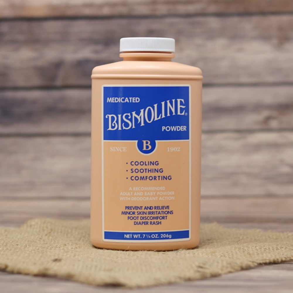 Container of medicated Bismoline powder with cooling and soothing properties, made in USA, part of Health & Wellness and Best Sellers collections, placed on rustic fabric surface.