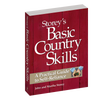 Book titled "Basic Country Skills" by John and Martha Storey, with a rustic red wooden background cover, offering practical self-reliance guidance for heritage and lifestyle book collections.