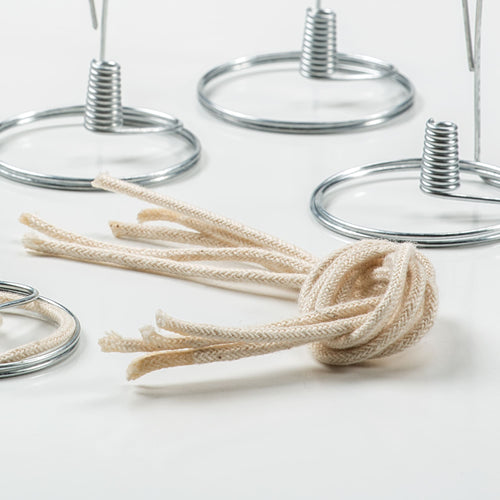 Braided cotton round wicks bundled together, surrounded by metal wick holders, handcrafted in USA, suitable for lamps and lighting, oil lamps, olive oil lamps, and parts and accessories collections.