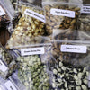 Close-up of assorted heirloom seed packets including Golden Bantam Corn, Tiger Eye Bean, Green Arrow Pea, and Calypso Bean, featuring organic varieties for farm and garden use, USA made and promo eligible.