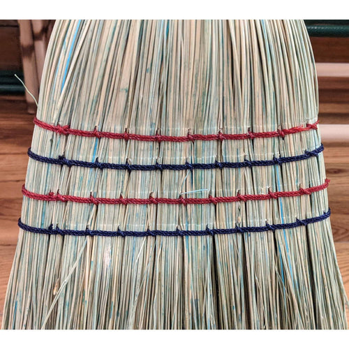 Close-up of handcrafted broom made with natural corn straw bound with alternating red and blue threads, showcasing quality Amish-made craftsmanship, ideal for household cleaning and home decor collections.