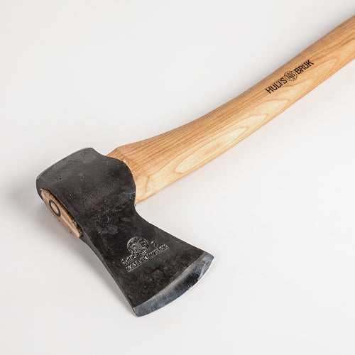 Hand-forged hatchet with a sharp single bit head and smooth wooden handle, crafted for farm, garden, camping, and wood cutting tasks, featuring unique Scandinavian craftsmanship.
