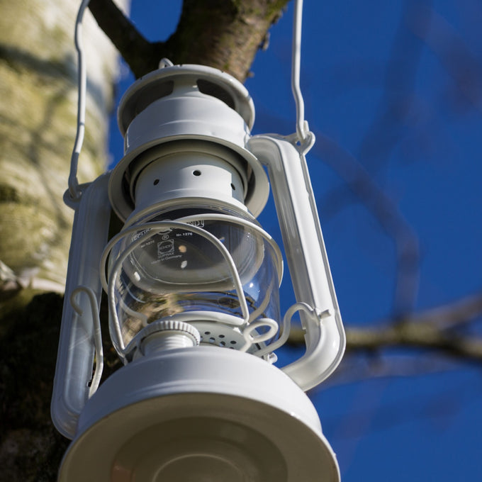 Handcrafted light gray galvanized oil lantern with thermal heat-resistant SUPRAX globe hanging from a tree branch against a clear blue sky, ideal for Camping, Lamps & Lighting, Emergency Supplies, and Outdoor collections.