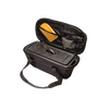 Black transport bag with sturdy handles holding a cast iron loaf pan and baking accessories, designed for secure storage and travel, ideal for camping, bread making, and farm tools.