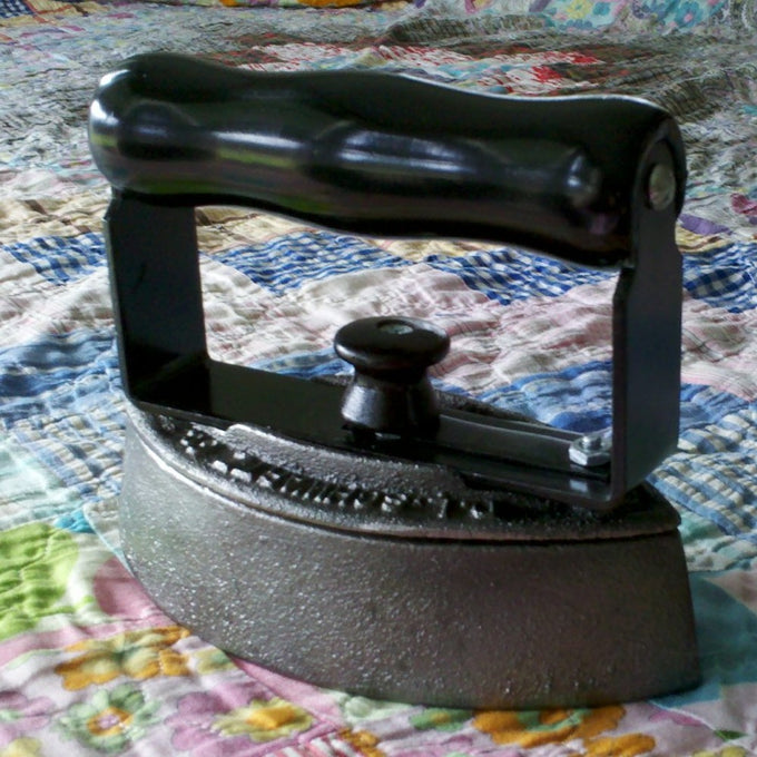 Handcrafted vintage-style sad iron with smooth black wooden handle and heavy cast iron base, made in USA, perfect for traditional ironing in Home & Decor and Laundry Supplies collections.