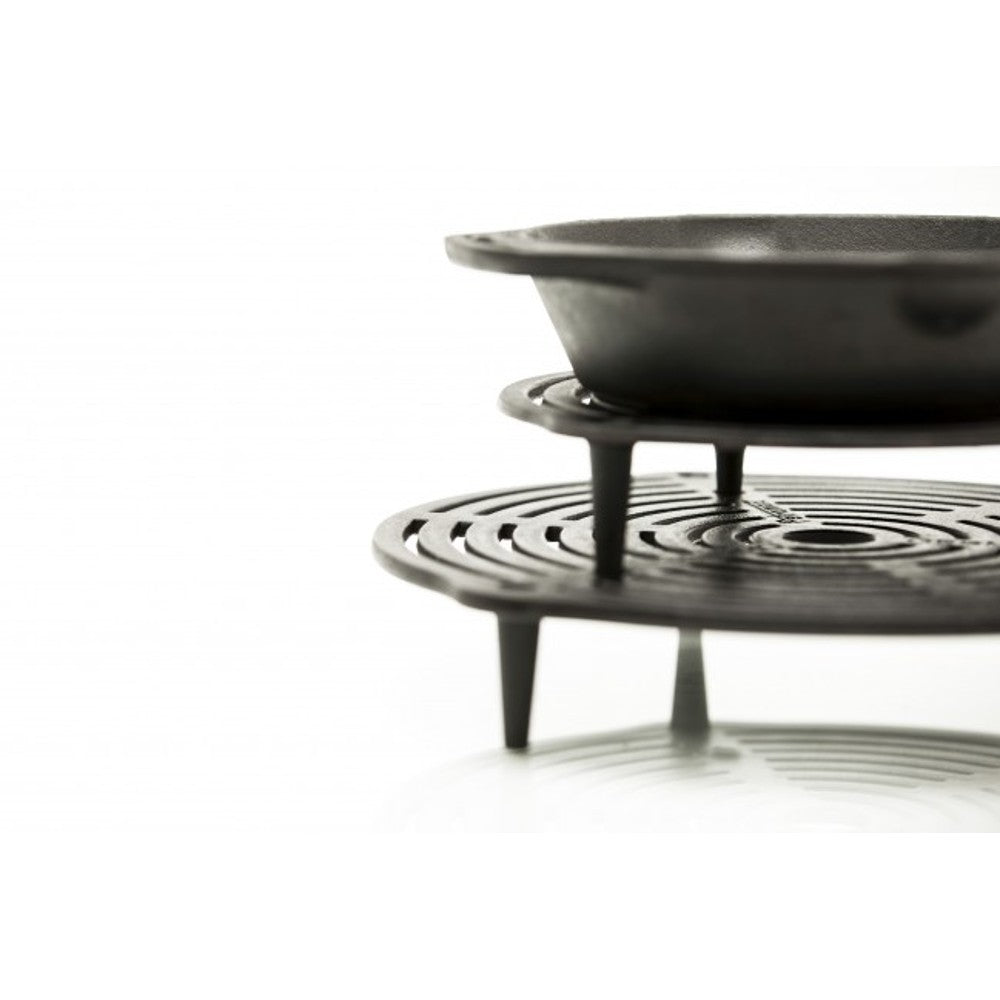 Solid cast iron stack grate with elevated legs supporting a pan above, designed for layered cooking and even heat distribution, suitable for Farm, Garden & Tool, Kitchen & Food, Camping, Cookware, Cast Iron, Best Sellers, and Promo Eligible collections.