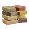 Stacked assortment of handcrafted natural soap bars in earthy tones, made in USA, highlighting gentle care for skin, featured in Health & Wellness, Soaps, and USA Made collections.