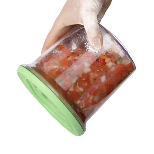 Hand holding a flexible green-lidded vacuum seal container filled with fresh tomato and vegetable salsa, designed for Kitchen & Food, Food Preservation, and Storage collections.