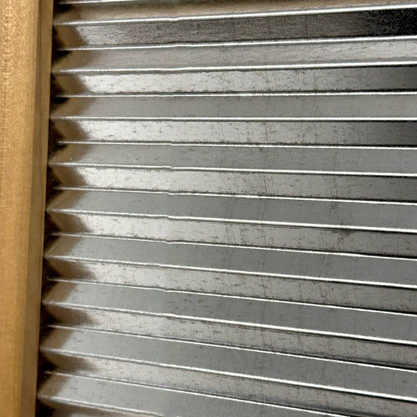 Close-up of a handcrafted galvanized wavy scrubbing surface with a smooth wooden frame, part of a miniature washboard ideal for Home & Decor, Laundry Supplies, and USA Made collections.