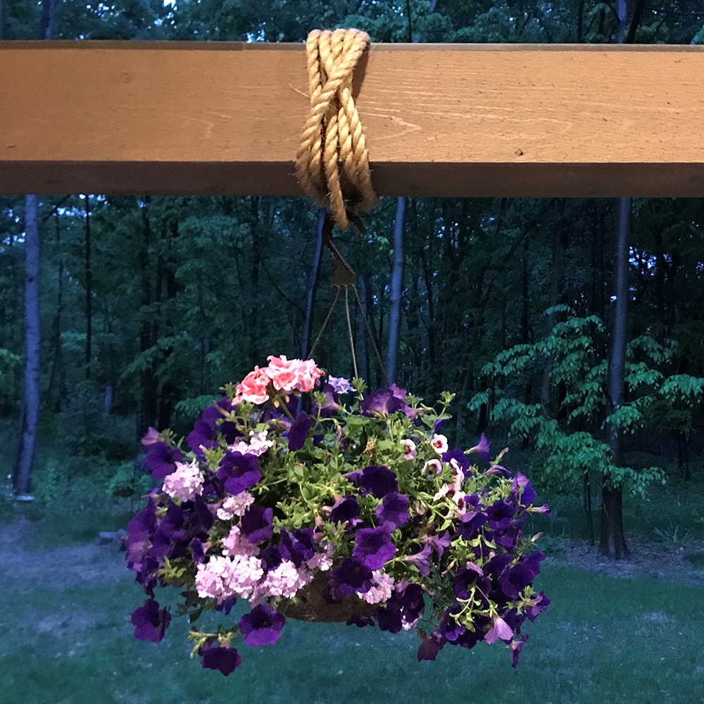 Natural fiber rope looped securely around a wooden beam, used to hang a vibrant flower basket outdoors, ideal for Farm, Garden & Tool and Hand Tools and Hardware collections.