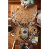 Four people assembling a unique-shaped jigsaw puzzle of a buck's head with 520 pieces on a wooden table, surrounded by coffee, juice, and an educational book about bucks in a cozy setting.