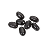 Seven glossy black jumbo licorice jelly beans arranged on a white background, part of Kitchen & Food and Snacks and Sweets collections.