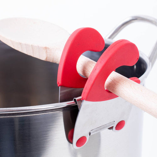 Stainless steel pot clip with red silicone grips holding a wooden spoon securely on the side of a pot, designed to keep utensils handy and off surfaces in Kitchen Gadgets and Cooking Helpers collections.