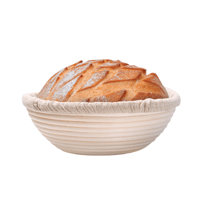 Handcrafted rattan bread proofing basket with a natural removable liner holding a golden artisan loaf, ideal for Kitchen & Food, Baking Supplies, and Bread Making collections.