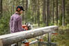 Man using portable chain sawmill to cut a log into lumber outdoors, featuring a sturdy metal frame and designed for ease of use in Farm, Garden & Tool, Wood Cutting and Hauling, and Best Sellers collections.