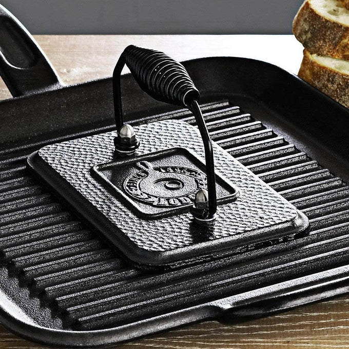 Seasoned cast iron rectangular grill press with heat-retaining surface and spring handle, designed for searing paninis and speeding cooking on grill or stovetop, ideal for Kitchen & Food and Cast Iron cookware collections.