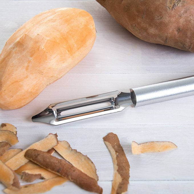 Handcrafted stainless steel vegetable peeler with solid aluminum handle peeling a sweet potato, ideal for Kitchen & Food, Specialty Equipment, Peelers and Pitters, USA Made, Best Sellers, Promo Eligible collections.