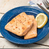 Two cooked salmon fillets seasoned with spices on a blue speckled plate, served with a lemon wedge, suitable for Kitchen & Food, Farm, Garden & Tool, Emergency Supplies, and Freeze Dried collections.