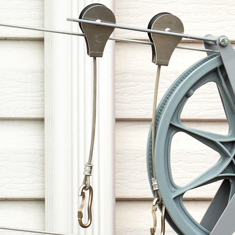 Close-up of metal laundry pulley system with steel cable and hooks attached, designed for outdoor clothesline use in Home & Decor, Laundry Supplies, and USA Made collections.