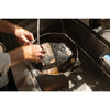 Hands rinsing a lightweight, smooth-surfaced cast iron skillet under running water in a stainless steel kitchen sink, highlighting its Amish-made craftsmanship and durable design for Kitchen & Food, Cast Iron, and USA Made collections.