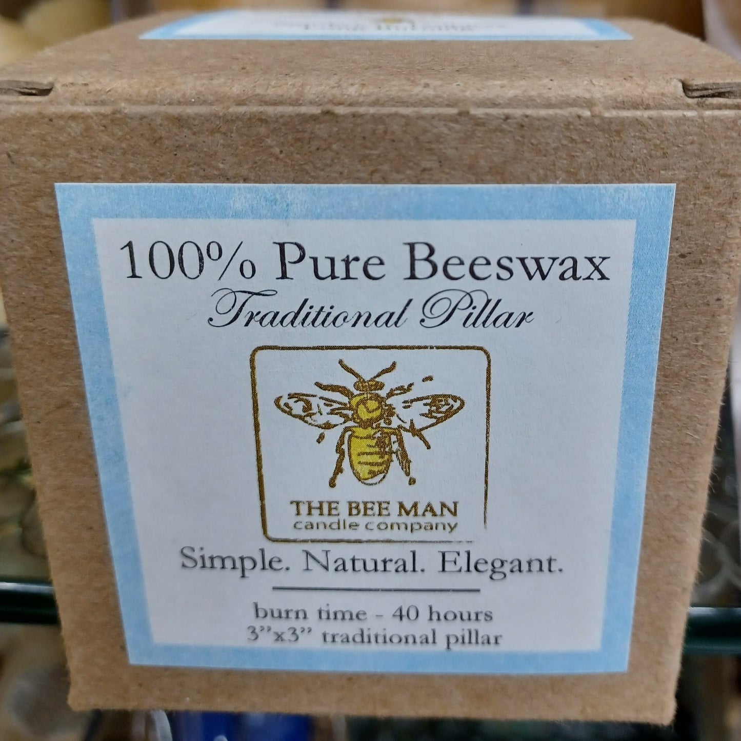 Packaging label for handcrafted 100% pure beeswax traditional pillar candle by The Bee Man Candle Company, emphasizing natural, simple, and elegant qualities, included in USA Made and Candles collections.