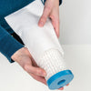 Hands holding a white fabric water filter cartridge with a blue plastic end, designed for use in farm, garden, emergency, and water treatment applications.