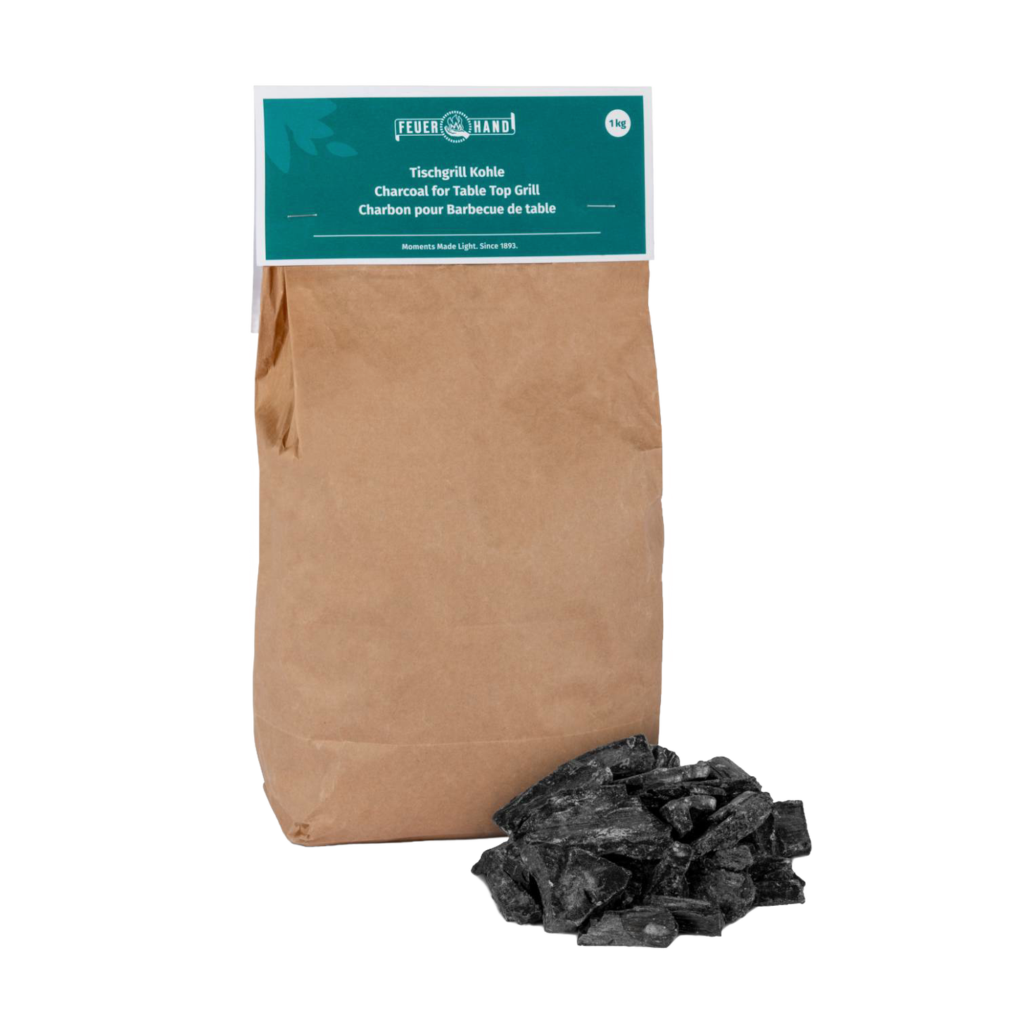 Brown paper bag of Feuerhand charcoal for tabletop grills with a small pile of black charcoal pieces, suitable for grilling in Stoves, Grilling, and Best Sellers collections.