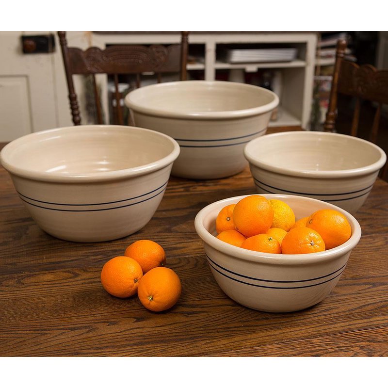 Set of four handcrafted stoneware mixing bowls with blue stripes, arranged on a wooden table with fresh oranges, ideal for Kitchen & Food and Baking Supplies collections.