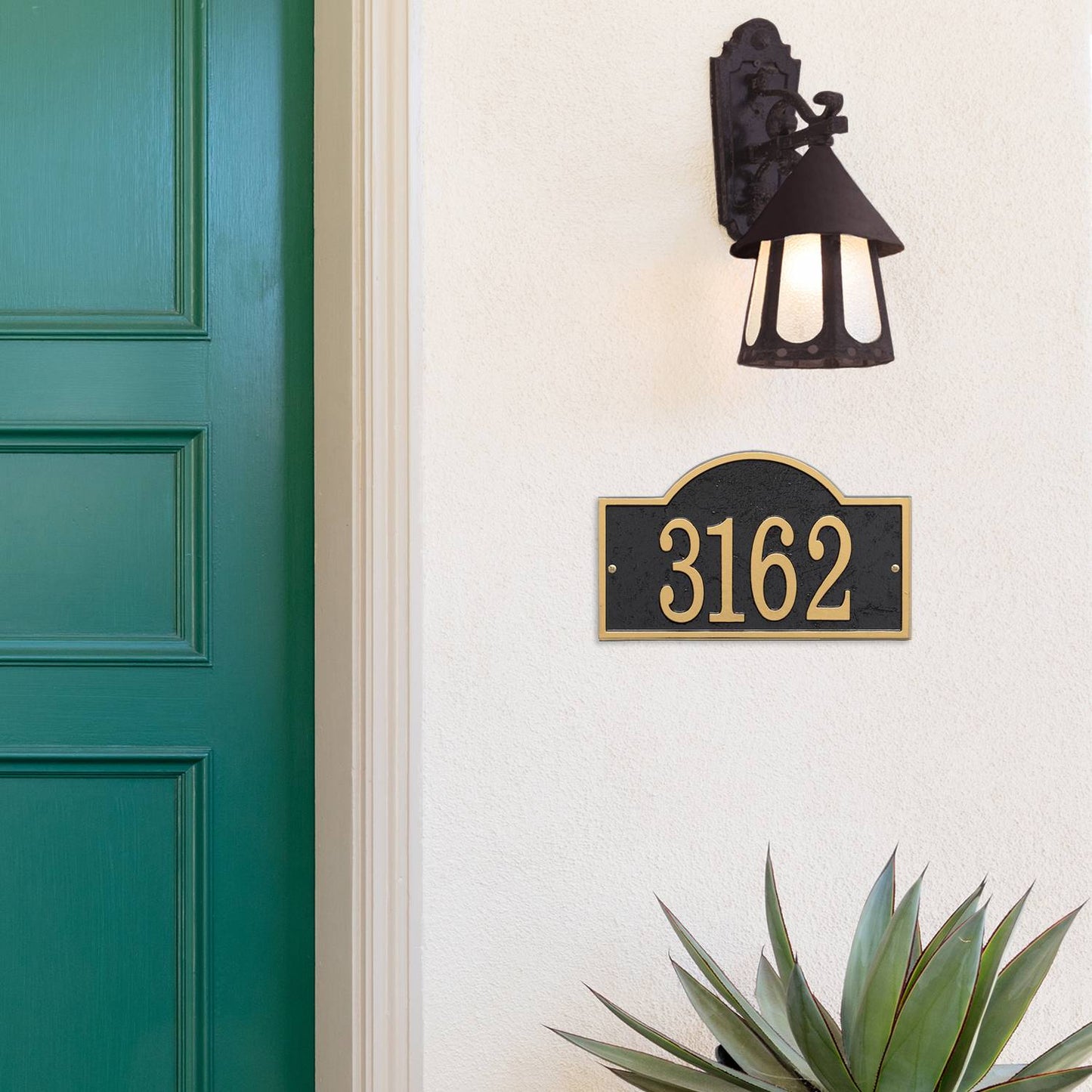 Handcrafted arched rectangle address plaque with black background and gold numbers, mounted on a light wall beneath a vintage-style outdoor lantern, featured in Home & Decor, Household Helpers, Mailboxes and Address Signs, USA Made, Best Sellers, and Promo Eligible collections.