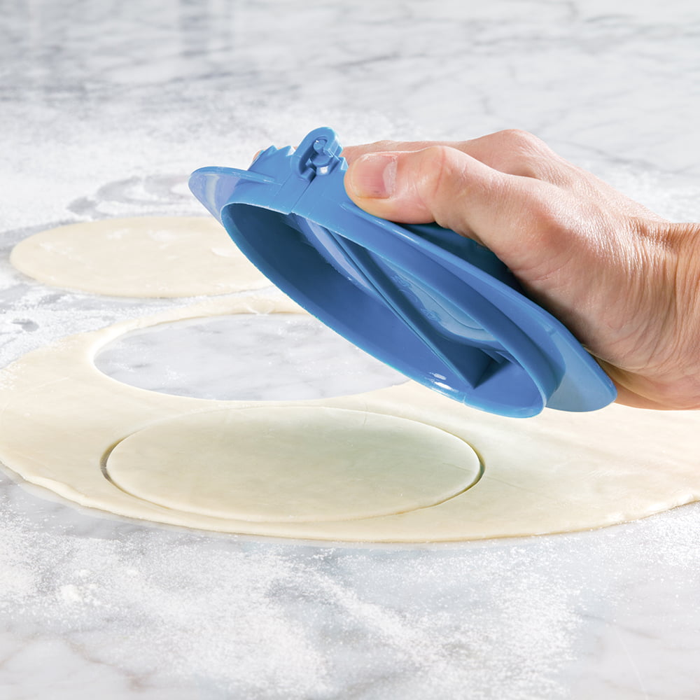 Blue dough press tool cutting and folding round dough circles for hand pies or pastries on a floured marble surface, part of Kitchen & Food, Baking Helpers, and Best Sellers collections.