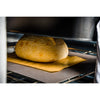 Close-up of a golden crusty batard loaf baking under a lightweight shell on a parchment-lined baking surface, showcasing cookware perfect for Kitchen & Food and Baking Supplies collections.
