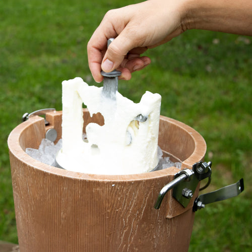 Close-up of a hand lifting the central churn dasher from a handcrafted wooden ice cream freezer filled with ice, showcasing a traditional Amish-made design in Kitchen & Food and Specialty Equipment collections.