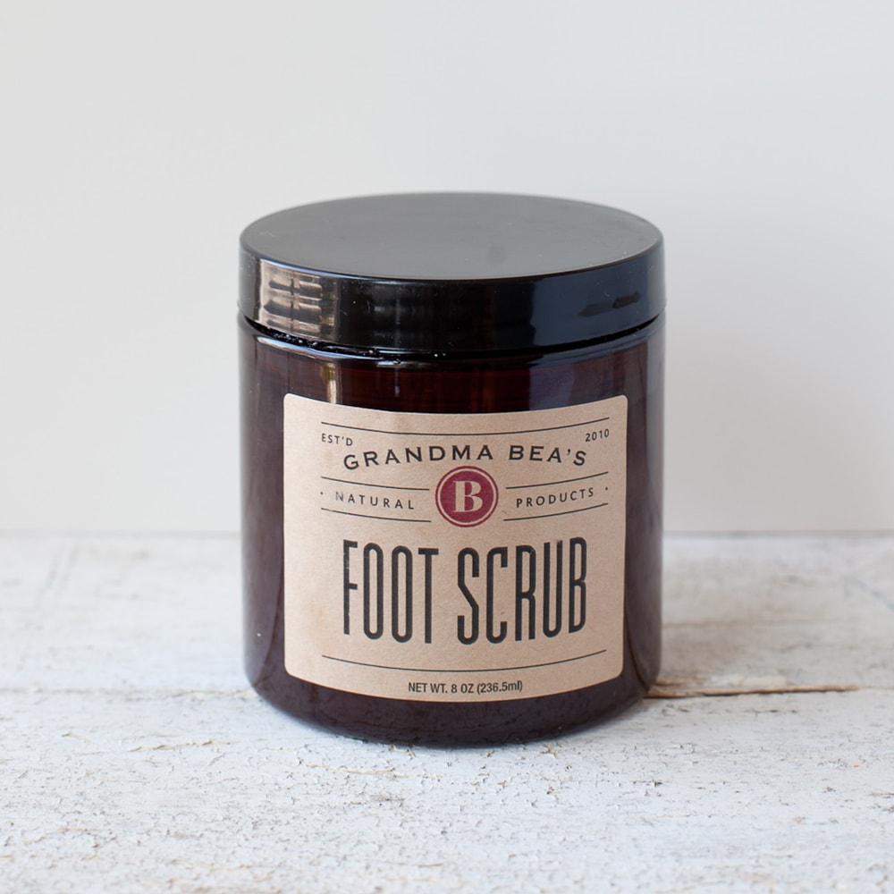Amber jar with black lid containing handcrafted foot scrub with natural ingredients, featured in Health & Wellness, Balms, Creams and Lotions, USA Made, Best Sellers, and Promo Eligible collections.